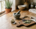 Mortar and pestle, scissors, shot glass and wooden chopping board arranged on a kitchen worktop in soft daylight